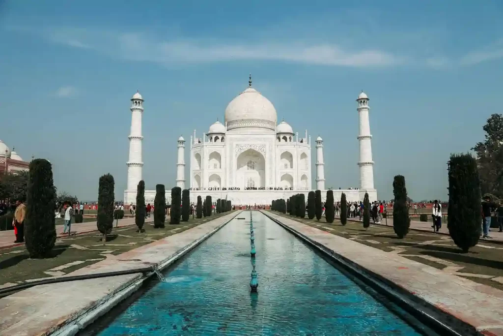 The Taj Mahal in Agra, India, reflected in a pool with a clear sunrise sky